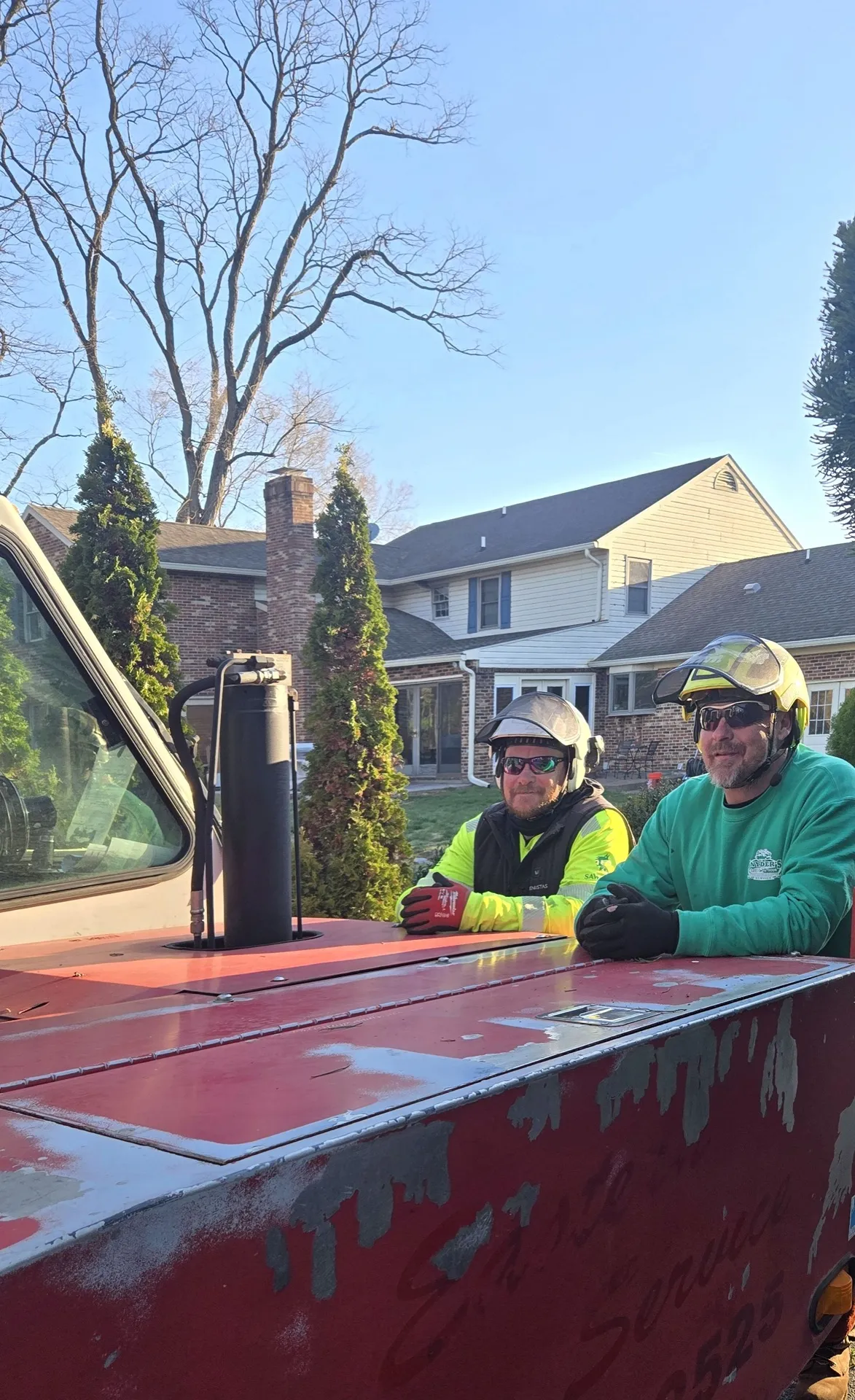 Two Snyder's Outdoor Solutions crew members in PPE on a job site.