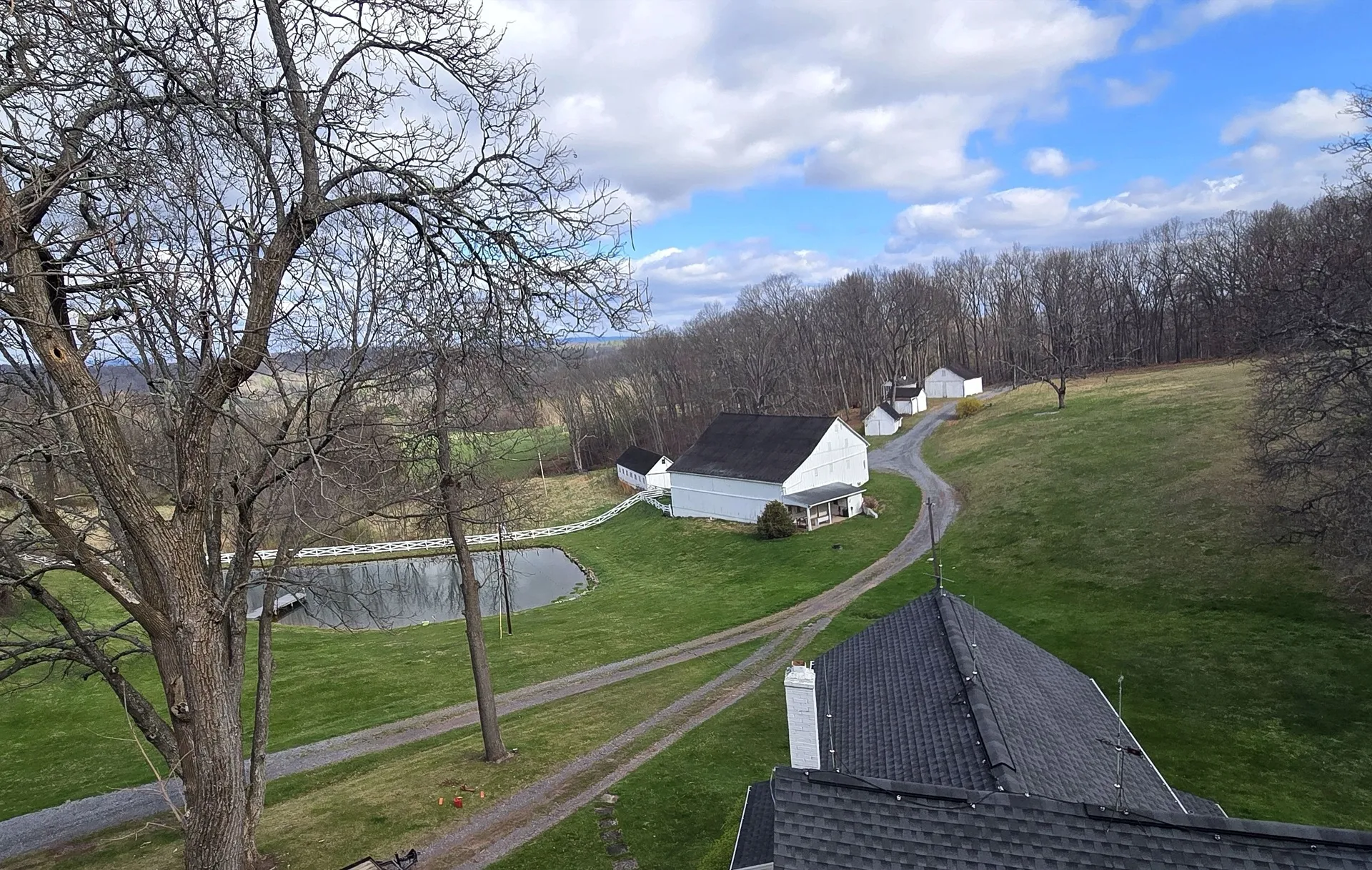 Aerial view of a Maryland farm property with pond, barn, and rolling countryside.
