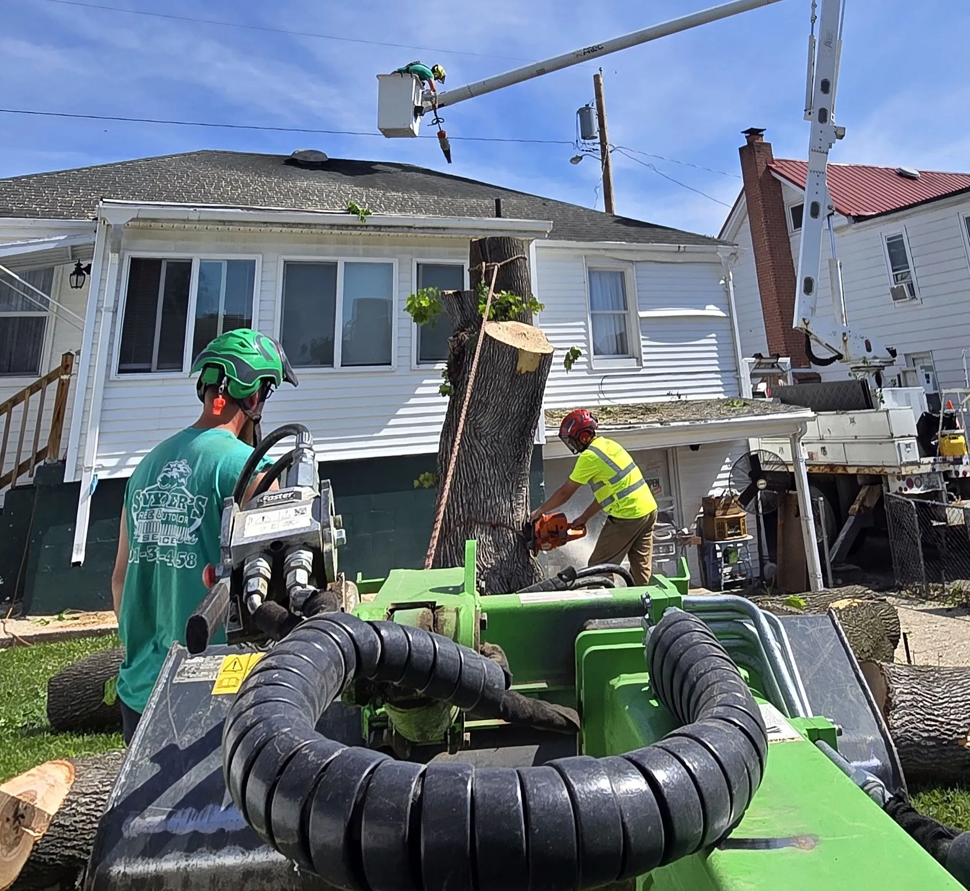 Snyder's crew member running a stump grinder on a residential job.