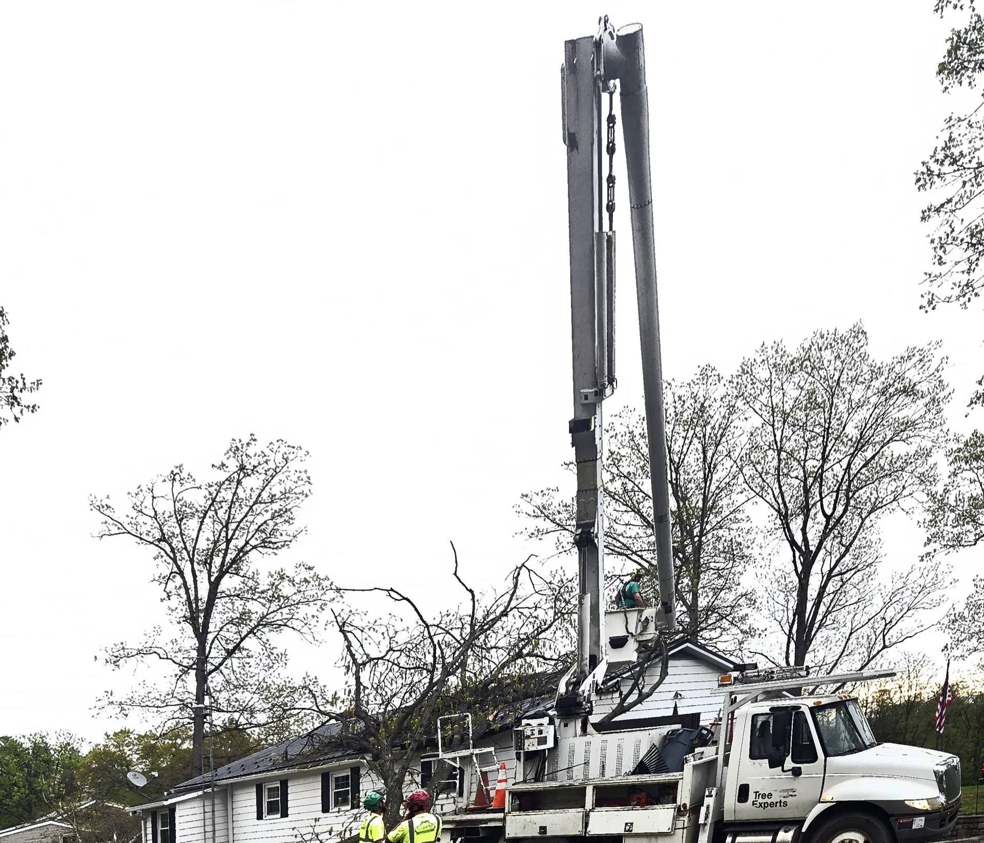 Snyder's bucket truck extended over a residential home at dusk.